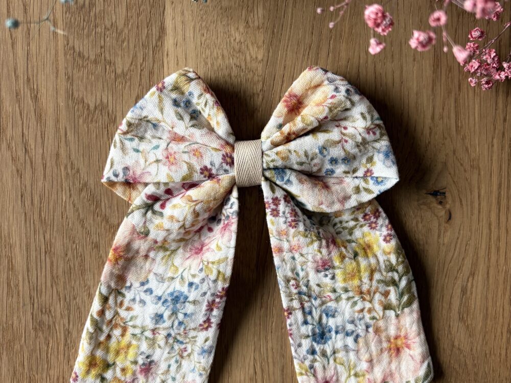 Spinka do włosów z kokardą - kolorowa łączka. Kolorowe małe kwiatki na jasnym tle. Spinka zapinana na metalową klamrę