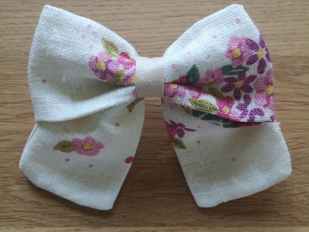 Spinka do włosów z kokardą lnianą, zapinana na metalową klamrę. Różowo - fioletowe kwiatki na jasnym tle