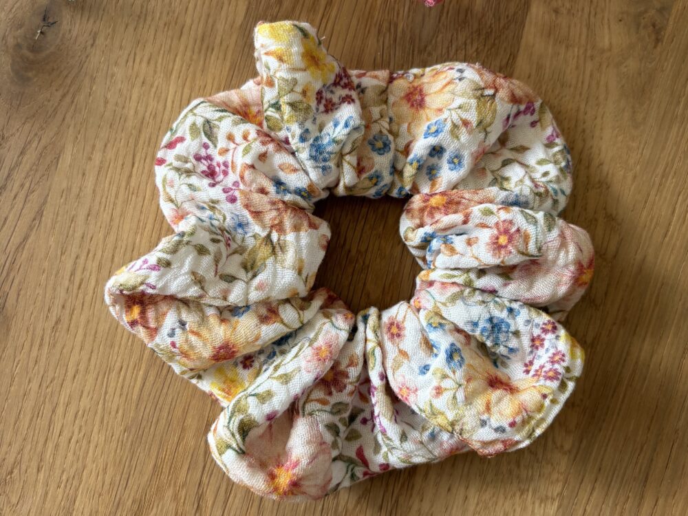 Scrunchie muślinowa - kolorowa łączka. kolorowe kwiatki na jasnym tle.