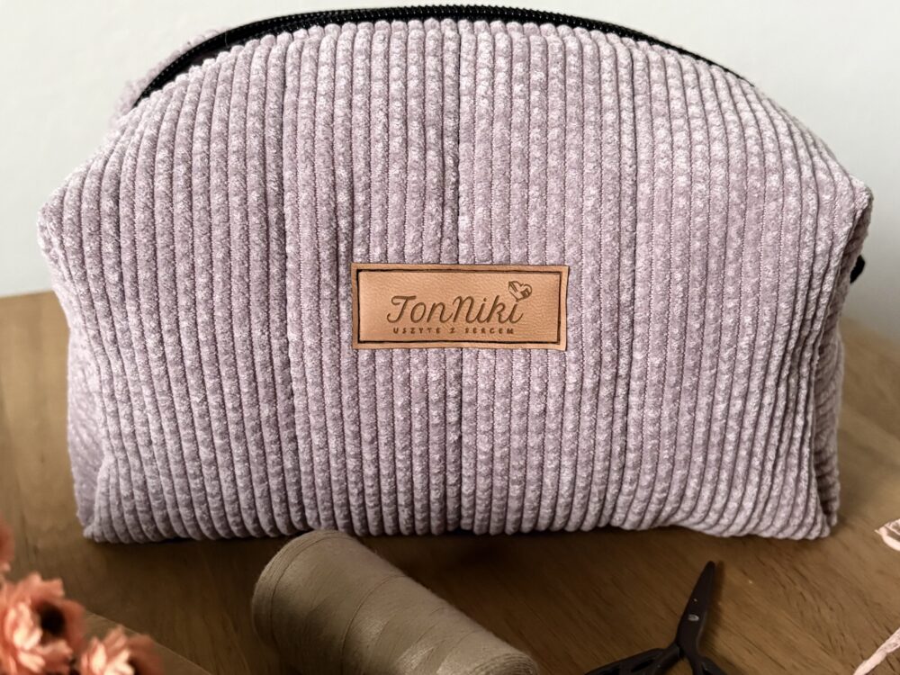 kosmetyczka damska, uszyta z różowego sztruksu z czarnymi detalami, zapinana na zamek